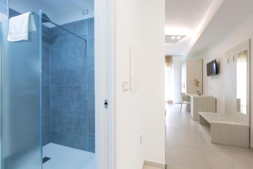 uma casa de banho com um chuveiro e uma porta de vidro em Alfema Rooms em Ugento