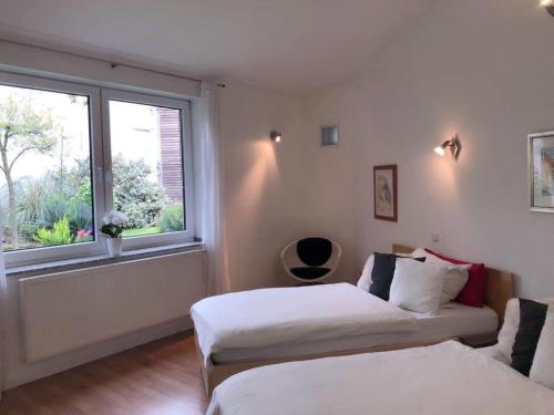 a bedroom with two beds and a window at Gästeapartment Kübel in Uedem