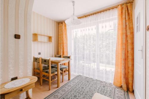 a room with a table and a large window at Wędrowiec in Karwia
