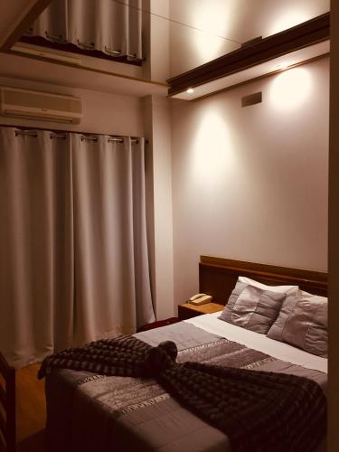 a bedroom with a bed and a shower curtain at Hotel Portinari in Porto