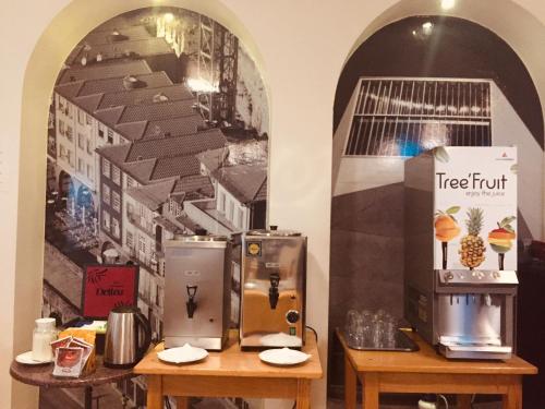 a wall with two refrigerators on two tables in a room at Hotel Portinari in Porto