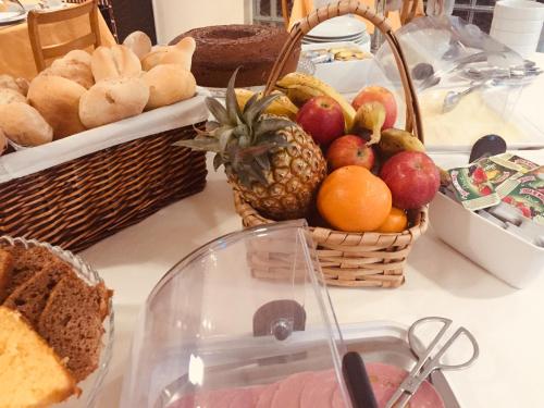 a table topped with baskets of fruit and bread at Hotel Portinari in Porto