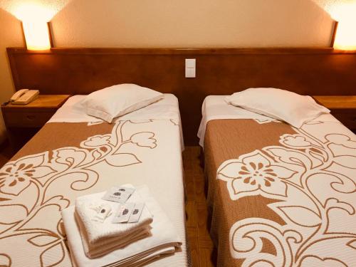 two beds with pillows and pillows on them at Hotel Portinari in Porto