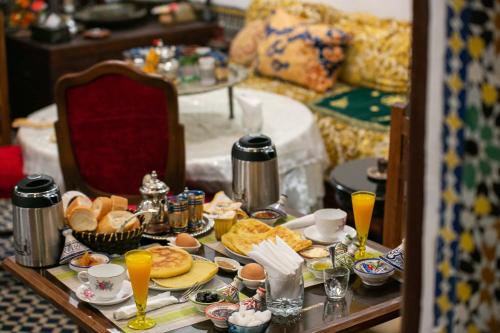- une table de petit-déjeuner avec des aliments et des boissons dans l'établissement Dar Alami Salaj, à Fès