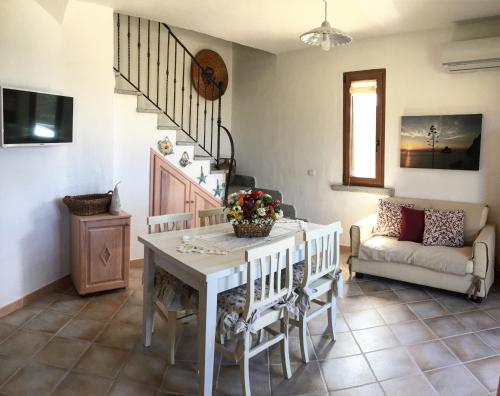 uma sala de estar com uma mesa e um sofá em Il Tramonto Tanca Piras em Nebida