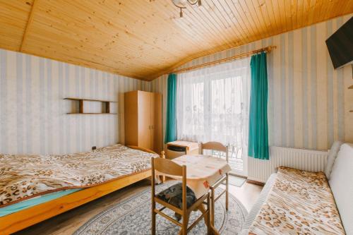 a bedroom with a bed and a table and a window at Wędrowiec in Karwia