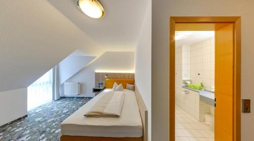 a bedroom with a bed and a bathroom at Landhotel Seerose in Langenzenn