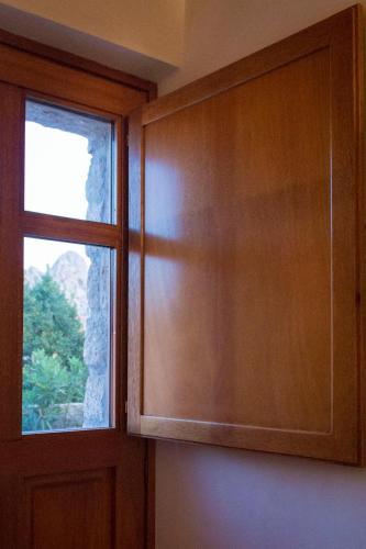a kitchen with a window and a wooden cabinet at Li Cimi in San Pantaleo