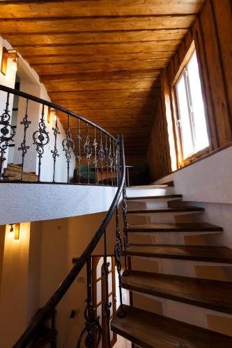 a staircase in a house with a wooden ceiling at Golden Gate in Akhaltsikhe