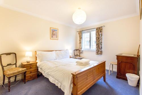 um quarto com uma cama, uma cadeira e uma janela em Central & stylish 3 bedroom, 2 bath, free parking em Edimburgo