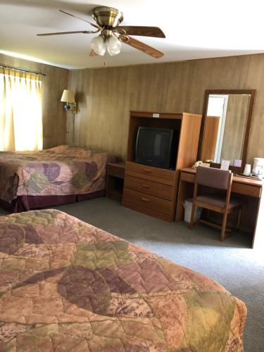 Cette chambre comprend 2 lits et une télévision à écran plat. dans l'établissement Coronado West Motel, à Lindsborg