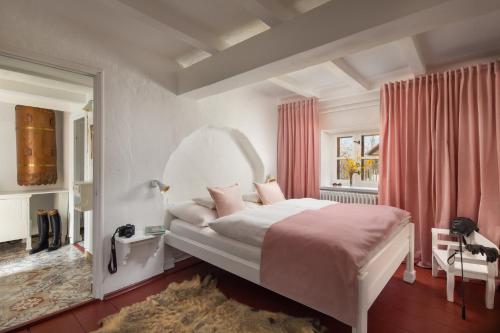 1 dormitorio con 1 cama blanca grande con sábanas rosas en Homoki Lodge - Nature Quest Resort - Adult Only en Ruzsa