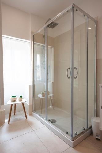 a glass shower in a bathroom with a table at Casamata in Ragusa