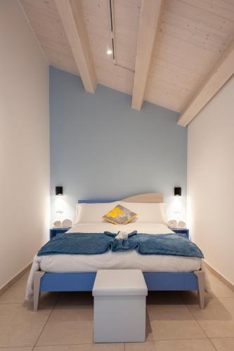 a bedroom with a bed with a blue wall at Casamata in Ragusa
