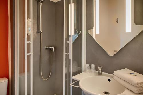a bathroom with a sink and a shower at ibis budget Redon in Redon