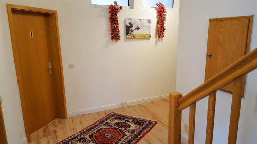 a hallway with a staircase with a door and a rug at Gästehaus Strudthoff in Ganderkesee