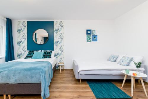 sypialnia z niebieskimi ścianami, łóżkiem i lustrem w obiekcie Sleepway Apartments - Blue Dream w Poznaniu