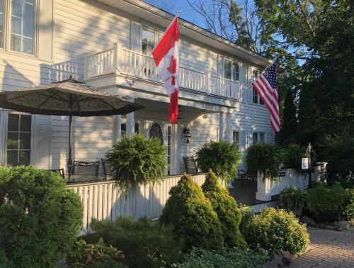 a house with two flags in front of it at Butler Creek House in Niagara on the Lake