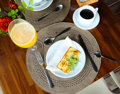 a plate with a slice of pizza and a glass of orange juice at Hotel da Pipa in Pipa