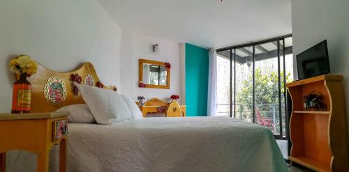 a bedroom with a bed and a large window at HOTEL EL PAN NUESTRO in Tepoztl&aacute;n