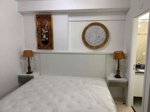 a white bedroom with a bed and two lamps at SOFISTICACAO Y LUXO PRACA DA REPUBLICA CON VAGA Y NETFLIX in Sao Paulo