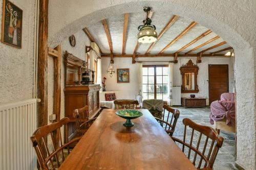 a dining room with a wooden table and chairs at Light-filled home with Garden near Beach in Anavissos