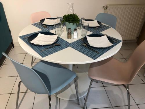 une table avec des chaises et une table blanche avec des serviettes dans l'établissement Clos des Ursulines, à Bayeux