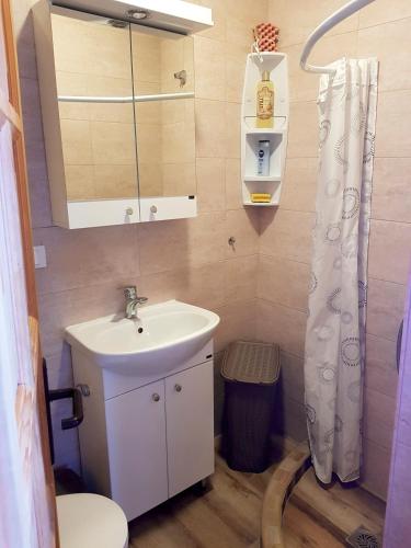 a bathroom with a sink and a toilet and a mirror at Summer Holiday House MM in Ulcinj