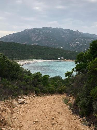a dirt road leading to a beach with a mountain at Li Cimi in San Pantaleo
