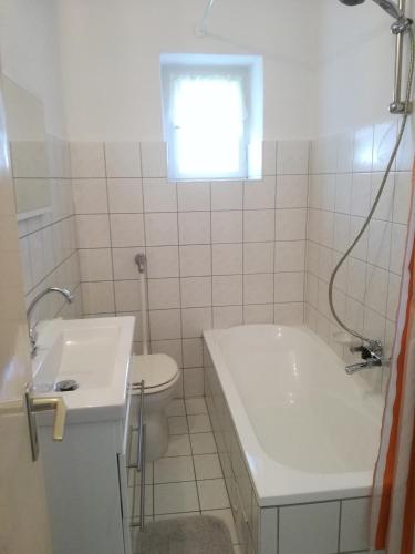 a bathroom with a tub and a toilet and a sink at Bochmann Cottage in Zalaszántó