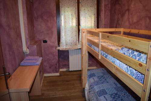 モンツァンバーノにあるcasa belvedereの二段ベッド1組、デスクが備わる小さな客室です。