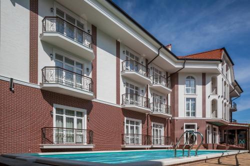 un edificio de apartamentos con piscina frente a él en Dacha Resort Hotel en Gelendzhik