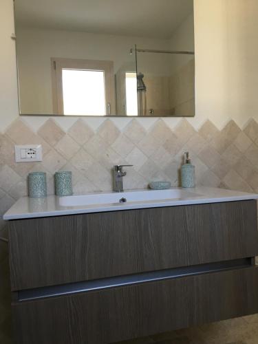 a bathroom with a sink and a mirror at Scrigno in Budoni