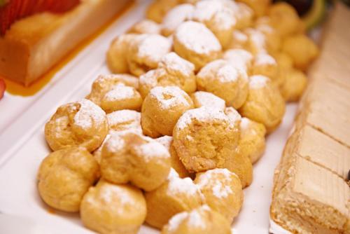 a pile of powdered sugar covered donuts on a table at Bluewater Hotel in Colonia Sant Jordi