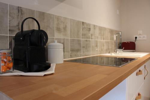 a kitchen with a counter with a sink and a bag at Manoir du Moustoir - Hôtel Les Empreintes in Saint-Évarzec