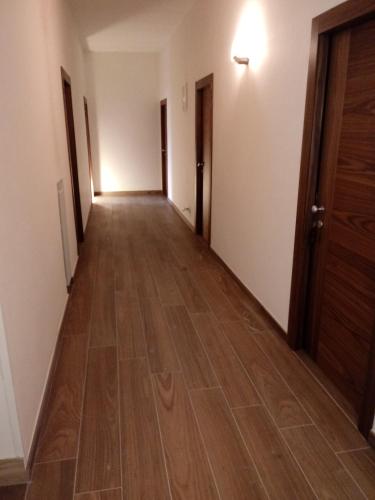 an empty corridor of an apartment with wooden floors at Albergo Ester in Piandimeleto