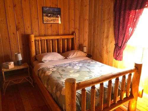 1 dormitorio con cama de madera en una cabaña en Half Moon Guest House, en Clearwater