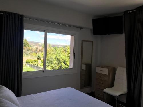 a bedroom with a large window with a view at Pensión CHE in O Pedrouzo