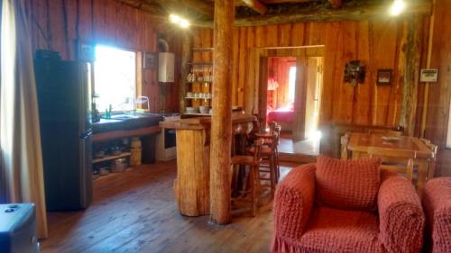 a room with a kitchen and a living room with wooden walls at La Ruta de Los Volcanes - Las Trancas Chillán in Las Trancas
