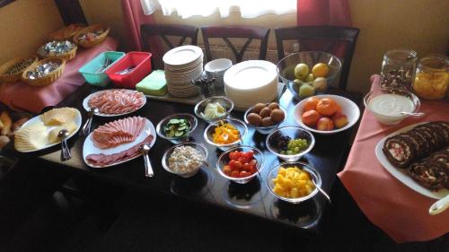 a table with plates and bowls of food on it at Pension KA.PR in Hluboká nad Vltavou
