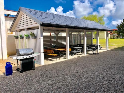 a pavilion with a grill and a picnic table at Błekitne Tarasy in Ustronie Morskie