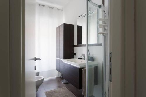 La salle de bains est pourvue d'un lavabo et d'une douche en verre. dans l'établissement Delizioso bilocale in Bocconi - Porta Romana, à Milan