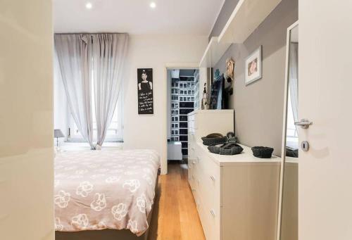sypialnia z łóżkiem, komodą i oknem w obiekcie Delizioso bilocale in Bocconi - Porta Romana w Mediolanie