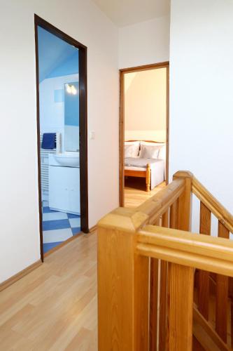 a room with a staircase and a bedroom with a mirror at Hotel Zámeček Janovičky in Broumov