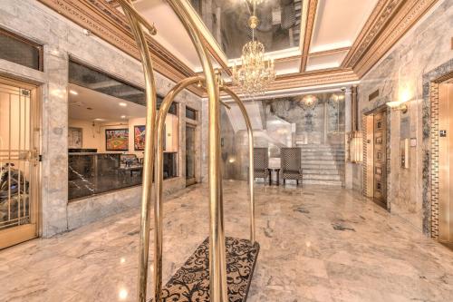 a large room with a chandelier and a staircase at Gaslamp Plaza Suites in San Diego