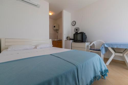 a bedroom with a bed with a blue blanket on it at Apartmani Mirta in Dramalj