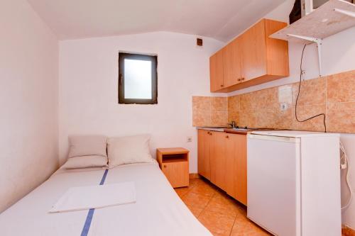 a small kitchen with a bed and a refrigerator at Raj mira in Utjeha