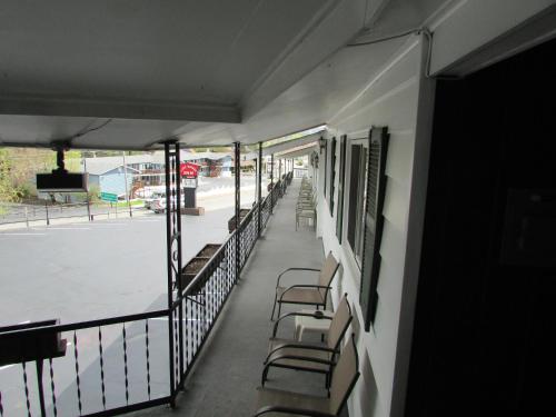 a balcony of a building with chairs and a street at The Lake George Inn in Lake George
