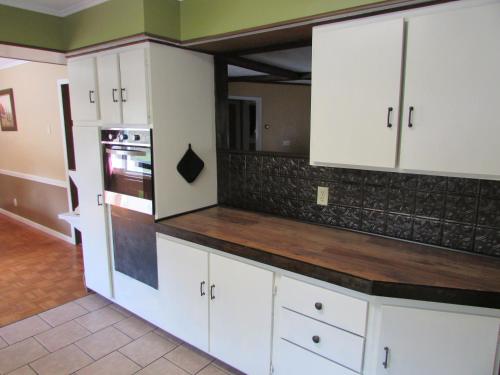 a kitchen with white cabinets and a counter top at The Lake George Inn in Lake George