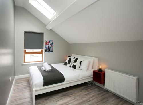 a bedroom with a bed with pillows and a window at University Road Apartments in Belfast